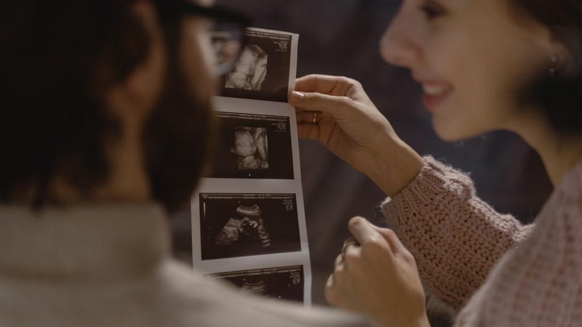 Couple excitedly viewing ultrasound images, celebrating pregnancy and parenthood.